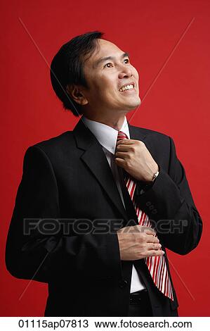 A businessman adjusts his tie View Large Photo Image Stock Image - A businessman adjusts his tie. Fotosearch