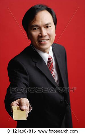 A businessman holds out his card View Large Photo Image Stock Photography - A businessman holds out his card. Fotosearch