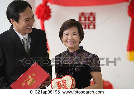 A couple smile as they hold wedding gifts View Large Photo Image Stock Photography - A couple smile as they hold wedding gifts. Fotosearch