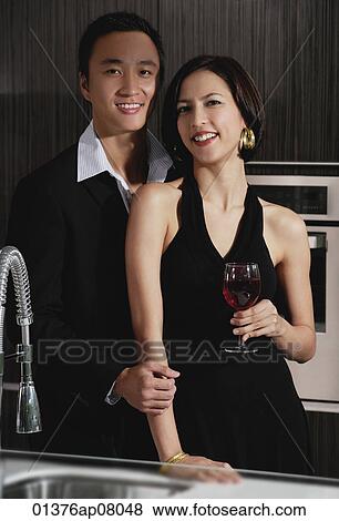 A couple smile at the camera while in the kitchen View Large Photo Image Stock Photo - A couple smile at the camera while in the kitchen. Fotosearch