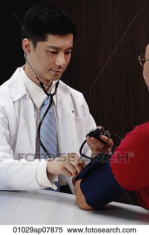 A doctor examines a patient View Large Photo Image Stock Photography - A doctor examines a patient. Fotosearch
