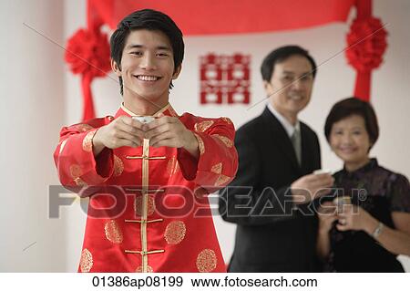A groom smiles at the camera as he holds out a cup View Large Photo Image Stock Photo - A groom smiles at the camera as he holds out a cup. Fotosearch
