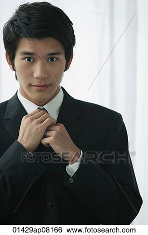 Stock Photograph - A groom wearing a suit looks at the camera. Fotosearch