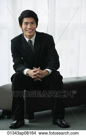 A groom wearing a suit smiles at the camera View Large Photo Image Picture - A groom wearing a suit smiles at the camera. Fotosearch