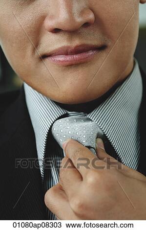 A man adjusts his tie View Large Photo Image Stock Image - A man adjusts his tie. Fotosearch