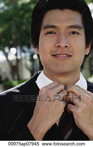 A man adjusts his tie View Large Photo Image Stock Photography - A man adjusts his tie. Fotosearch