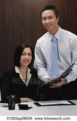 A man and a woman smile at the camera while they are at work View Large Photo Image Picture - A man and a woman smile at the camera while they are at work. Fotosearch