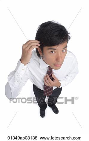 A man fixes his hair as he looks at the camera View Large Photo Image Stock Photo - A man fixes his hair as he looks at the camera. Fotosearch