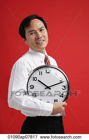 A man holds a clock View Large Photo Image Stock Photo - A man holds a clock. Fotosearch