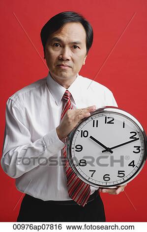 A man holds a clock View Large Photo Image Stock Photograph - A man holds a clock. Fotosearch