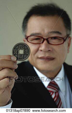 A man holds out a Chinese coin View Large Photo Image Stock Image - A man holds out a Chinese coin. Fotosearch