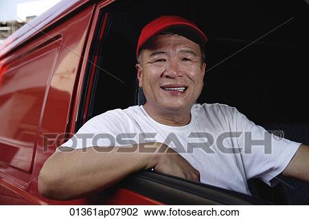 Stock Image - A man in a red van smiles at the camera. Fotosearch