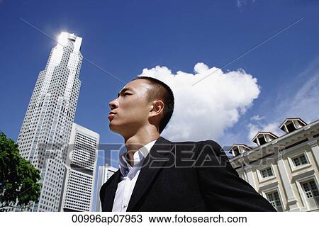 A man in a suit with a skyscraper behind him View Large Photo Image Stock Image - A man in a suit with a skyscraper behind him. Fotosearch