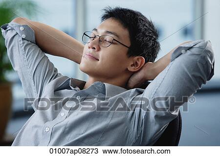 A man relaxes at his desk View Large Photo Image Stock Image - A man relaxes at his desk. Fotosearch