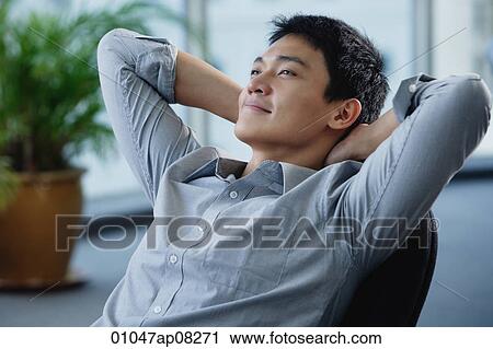 A man relaxes at his desk View Large Photo Image Stock Image - A man relaxes at his desk. Fotosearch