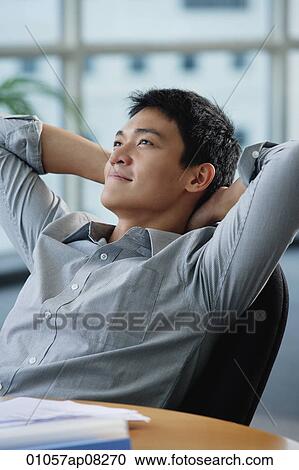 A man relaxes at his desk View Large Photo Image Stock Image - A man relaxes at his desk. Fotosearch