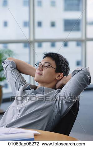 A man relaxes at his desk View Large Photo Image Stock Image - A man relaxes at his desk. Fotosearch