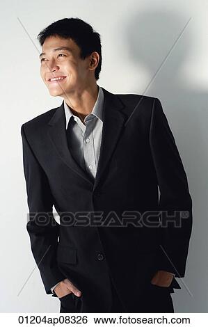 A man smiles as he stands with his hands in his pockets View Large Photo Image Stock Photograph - A man smiles as he stands with his hands in his pockets. Fotosearch