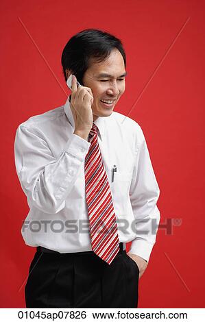 A man smiles as he talks on a cellphone View Large Photo Image Stock Photograph - A man smiles as he talks on a cellphone. Fotosearch