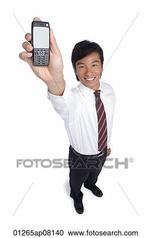 A man smiles at the camera as he holds out his cellphone View Large Photo Image Stock Image - A man smiles at the camera as he holds out his cellphone. Fotosearch