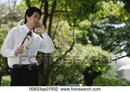 A man talks on his cellphone in the park View Large Photo Image Stock Image - A man talks on his cellphone in the park. Fotosearch