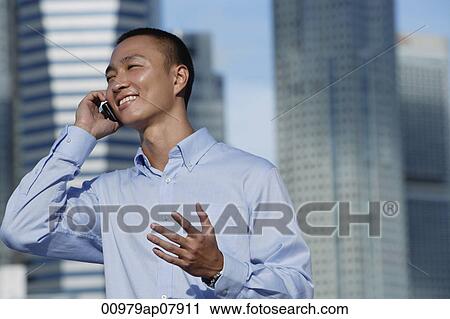 A man talks on his cellphone outdoors View Large Photo Image Stock Image - A man talks on his cellphone outdoors. Fotosearch