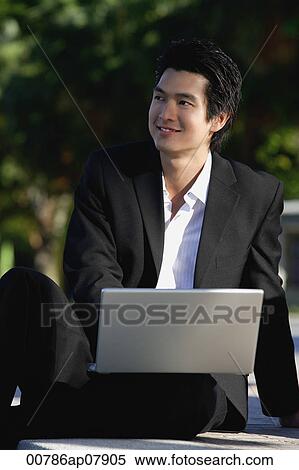 A man uses his laptop in the park View Large Photo Image Stock Photography - A man uses his laptop in the park. Fotosearch