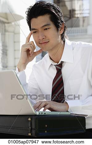 A man uses his laptop outside View Large Photo Image Stock Photo - A man uses his laptop outside. Fotosearch