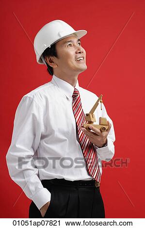 Stock Image - A man wearing a shirt and tie with a hardhat. Fotosearch