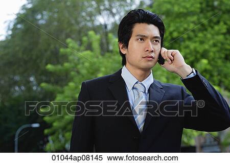A man wearing a suit talks on his cellphone View Large Photo Image Stock Photography - A man wearing a suit talks on his cellphone. Fotosearch