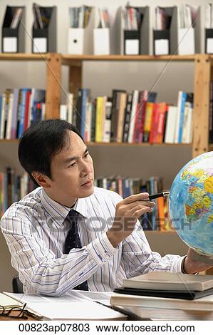 A man working with a globe on the desk View Large Photo Image Stock Image - A man working with a globe on the desk. Fotosearch
