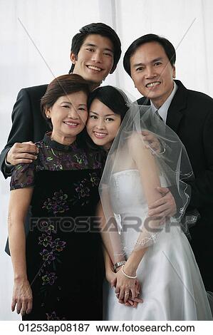A newlywed couple and their family smile at the camera together View Large Photo Image Stock Photo - A newlywed couple and their family smile at the camera together. Fotosearch