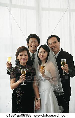 A newlywed couple and their family smile at the camera together View Large Photo Image Stock Photo - A newlywed couple and their family smile at the camera together. Fotosearch