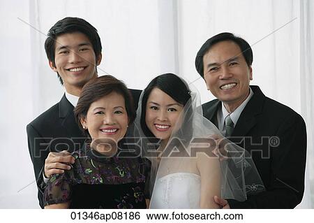 A newlywed couple and their family smile at the camera together View Large Photo Image Stock Photograph - A newlywed couple and their family smile at the camera together. Fotosearch