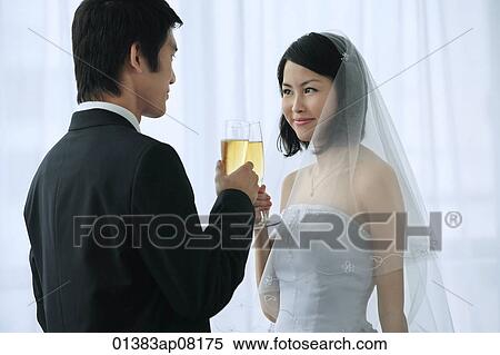 A newlywed couple hold out their champagne glasses for a toast View Large Photo Image Stock Photography - A newlywed couple hold out their champagne glasses for a toast. Fotosearch