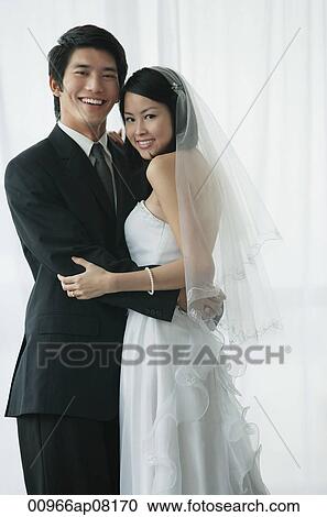A newlywed couple hug and smile at the camera View Large Photo Image Stock Image - A newlywed couple hug and smile at the camera. Fotosearch