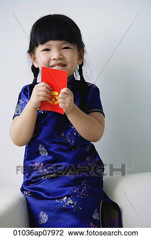 A small girl holds a red packet as she looks at the camera View Large Photo Image Stock Image - A small girl holds a red packet as she looks at the camera. Fotosearch