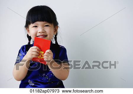 A small girl holds a red packet as she looks at the camera View Large Photo Image Stock Image - A small girl holds a red packet as she looks at the camera. Fotosearch