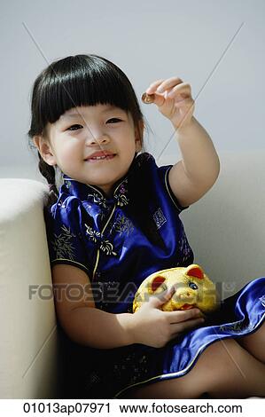 A small girl in blue silk cheongsam plays with a piggy bank View Large Photo Image Stock Image - A small girl in blue silk cheongsam plays with a piggy bank. Fotosearch