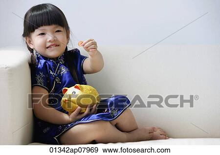 A small girl in blue silk cheongsam plays with a piggy bank View Large Photo Image Stock Photo - A small girl in blue silk cheongsam plays with a piggy bank. Fotosearch
