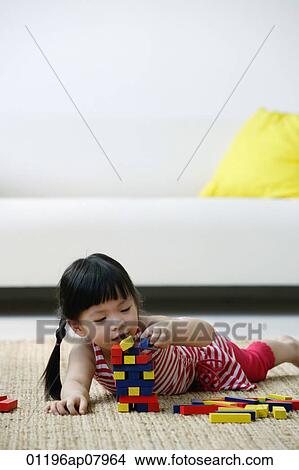 A small girl plays with blocks on the floor View Large Photo Image Picture - A small girl plays with blocks on the floor. Fotosearch