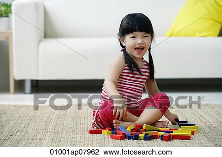 A small girl plays with blocks on the floor View Large Photo Image Stock Image - A small girl plays with blocks on the floor. Fotosearch