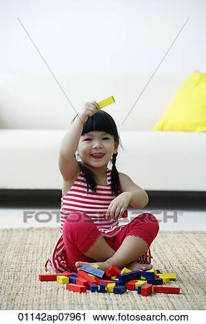 A small girl plays with blocks on the floor View Large Photo Image Stock Image - A small girl plays with blocks on the floor. Fotosearch