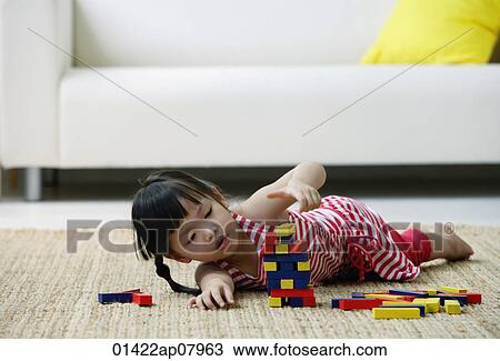 A small girl plays with blocks on the floor View Large Photo Image Stock Image - A small girl plays with blocks on the floor. Fotosearch