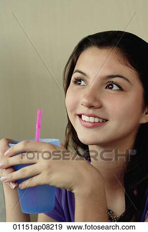 A teenage girl smiles as she has a drink View Large Photo Image Stock Photo - A teenage girl smiles as she has a drink. Fotosearch