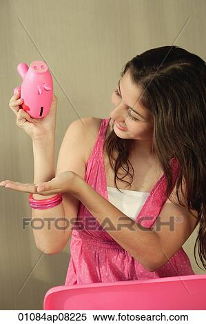 A teenage girl tries to get money from a piggy bank View Large Photo Image Stock Photography - A teenage girl tries to get money from a piggy bank. Fotosearch