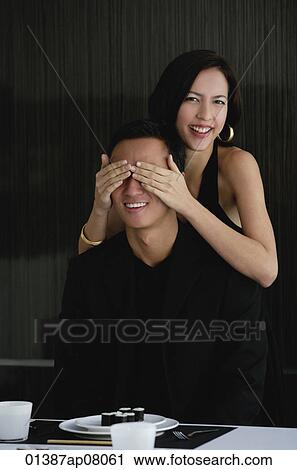 A woman covers her boyfriends eyes as she prepares to surprise him with dinner View Large Photo Image Stock Image - A woman covers her boyfriends eyes as she prepares to surprise him with dinner. Fotosearch