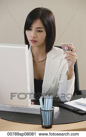 A woman drinks Chinese tea while she works View Large Photo Image Stock Image - A woman drinks Chinese tea while she works. Fotosearch