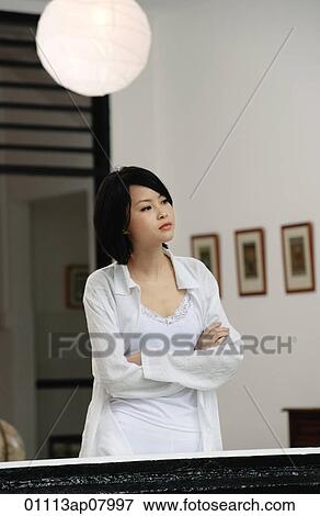 A woman folds her arms in her house View Large Photo Image Stock Photo - A woman folds her arms in her house. Fotosearch