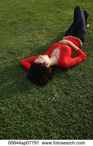A woman relaxes on grass View Large Photo Image Stock Image - A woman relaxes on grass. Fotosearch